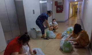 Người dân chung cư 12T2 (Nại Hiên Đông, Sơn Trà, Đà Nẵng) nhận hàng đặt mua từ tổ COVID-19 cộng đồng. Ảnh: Nguyễn Thành.