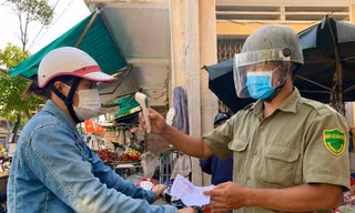 Người dân trước khi vào chợ đều phải xuất trình phiếu và được đo thân nhiệt. Ảnh: Nguyễn Ngọc