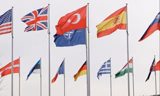 Quốc kỳ của các thành viên NATO trước trụ sở của khối tại Bỉ. (Ảnh: Reuters)