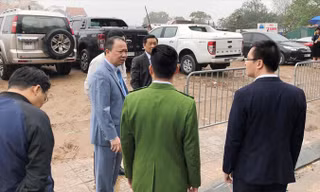 Có đủ lực lượng trong tay, nhưng sáng 22/2 khi được đại diện HĐND Hà Nội chất vấn, Phó Chủ tịch quận Tây Hồ Nguyễn Lê Hoàng (thứ 2, từ trái) chỉ đứng nhìn bãi xe lậu (phía sau) hoạt động.