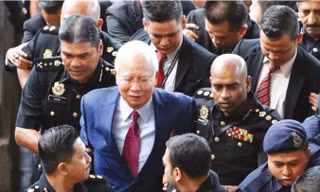 Cựu Thủ tướng Najib Razak rời tòa trước sự bao vây của báo chí. Ảnh: Straits Times.