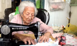 Bà Võ Thị Vân Khanh mải miết từng đường may để có những chiếc chăn ấm tặng người nghèo. Ảnh H. Văn