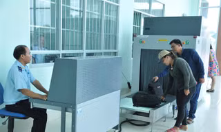 Hành khách cho hành lý đi qua máy soi chiếu của hải quan để kiểm tra. Ảnh: Tuấn Nguyễn.