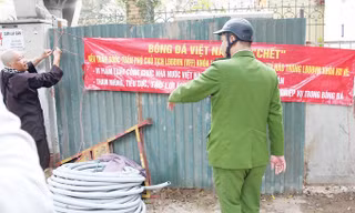 Cựu trọng tài bóng đá Dương Mạnh Hùng tháo gỡ băng-rôn theo yêu cầu của cơ quan chức năng. Ảnh: Thành Duy.