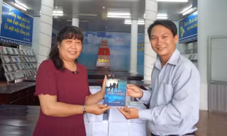 Nhà báo Trương Hòa Hội tặng sách cho bà Phan Thị Thùy Giang, Giám đốc Thư viện TP Cần Thơ.