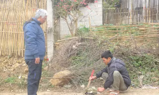 Bác sỹ Đại (bìa trái) và người dân làng Khuổi Mươi thắp nhang tưởng nhớ đến các chiến sỹ áo trắng đã hy sinh vì quê hương (ảnh chụp chiều ngày 16/2/2016). Ảnh: Duy Chiến