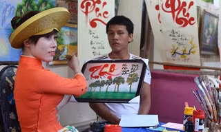 Một cô đồ đang múa bút. Ảnh: Sáu Nghệ
