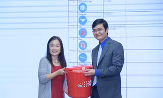Anh Bùi Quang Huy tiếp nhận bộ đồ thiết yếu cho người cao tuổi ứng phó với lũ lụt từ bà Naomi Kitahara. Ảnh: Xuân Tùng