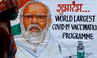 Một người phụ nữ bước qua bức tranh chân dung Thủ tướng Ấn Độ Narendra Modi. Ảnh: Reuters
