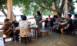 Các thực khách ngồi ăn lẩu ở nhà hàng ven sông của Jutimanon. Ảnh: Reuters