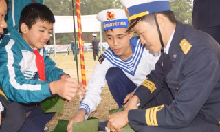 Cán bộ, chiến sĩ Lữ đoàn Hải quân đánh bộ 147 và các em học sinh cùng gói bánh chưng tặng người nghèo đón Tết. Ảnh: Nguyễn Minh.
