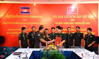 Đại tá Hàn Mạnh Thắng, Vụ trưởng Vụ Pháp chế (Bộ Quốc phòng Việt Nam, bên phải) và Đại tướng Mom Sophat, Cục trưởng Cục pháp chế (Bộ Quốc phòng Vương quốc Campuchia) ký biên bản hội đàm.
