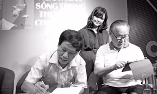 Vũ Công Chiến ký tặng sách trong buổi ra mắt “Hồi ức lính” năm ngoái. Bên cạnh là vợ anh và nhà văn Ngô Thảo. Ảnh: Nguyễn Đình Toán.