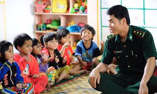Trung úy Nguyễn Bá Truyền đang dạy Tranh (thứ 4 từ trái sang) và các cháu nhỏ ở trường mầm non A Đớt ca hát.