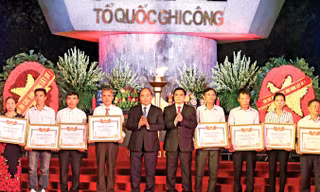 Thủ tướng Nguyễn Xuân Phúc và Trưởng ban Tổ chức Trung ương Phạm Minh Chính trao Bằng Tổ quốc ghi công cho đại diện thân nhân các liệt sỹ. Ảnh: Thống Nhất.
