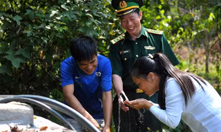 Niềm vui của người lính biên phòng Pò Mã và người dân thôn Nà Lẹng bên bể nước sạch trong thôn. Ảnh: Xuân Tùng.