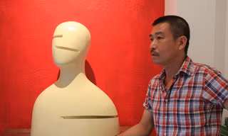 Lê Thiết Cương và “Chân dung 2” - tác phẩm trong triển lãm điêu khắc Mặt của anh. Ảnh: N.M.Hà.