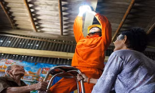 Vợ chồng ông Phan Thanh Quang (ấp Mũi, xã Đất Mũi, Ngọc Hiển, Cà Mau) vui mừng được công nhân ngành điện thay thế đường dây, bóng đèn mới.