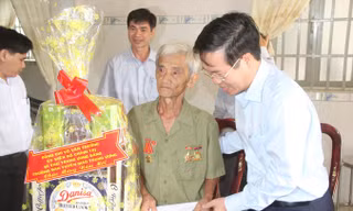 Ông Võ Văn Thưởng tặng quà cho thương binh Nguyễn Trung Bình. Ảnh: M.T.