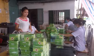 Lê Thị Tỉnh (đứng) bên các sản phẩm trà sản xuất từ những cây dược liệu.