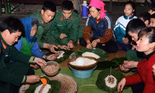 Bộ đội và dân bản gói bánh chưng đón Tết.