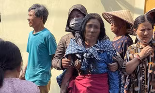 Người mẹ bị con tưới xăng đốt nhà ở Hưng Yên được người dân đưa ra khỏi hiện trường vụ hỏa hoạn.