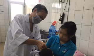 Bác sĩ Tâm thăm khám cho bệnh nhi bị bại não. Ảnh: Hà Quyên. 