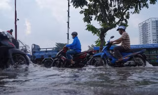 Người dân TPHCM bì bõm về nhà khi triều cường dâng cao