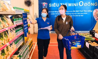 Tình nguyện viên hướng dẫn người dân chọn nhu yếu phẩm tại siêu thị 0 đồng thị xã Sơn Tây.
