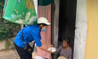 Thanh niên tình nguyện trao tặng suất cơm cho người nghèo trong chương trình chương trình “Triệu bữa cơm - Hà Nội nghĩa tình”