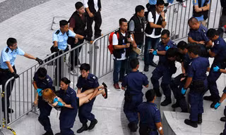  Cảnh sát Hồng Kông khiêng từng sinh viên ra khỏi trụ sở chính quyền - Ảnh: Reuters 
