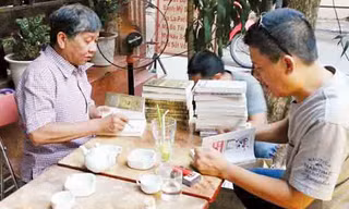 Nguyễn Việt Hà (phải) đang ký sẵn vào 4 đầu sách tặng bạn đọc. Đối diện là bạn văn Nguyễn Huy Thiệp. ảnh: n.t.quý
