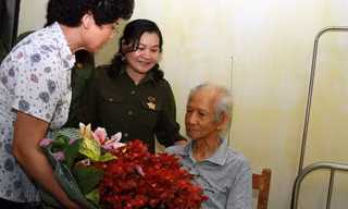 Các cựu nữ TNXP và thành viên chương trình “Hát mãi ca khúc bài ca cô gái mở đường” tặng hoa nhạc sĩ Xuân Giao. Ảnh: Mai Xuân Tùng