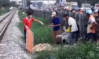 Lực lượng chức năng đang giải quyết vụ tai nạn, đưa nạn nhân ra khỏi khu vực đường tàu