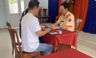 Lực lượng CSGT làm việc với tài xế lái xe ô tô đi vào làn đường cho xe máy trên cầu Phú MỹẢnh: PC08