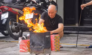 Người dân có thói quen sắp mâm lễ cúng, đốt vàng mã ngay tại vỉa hè, lòng đường Ảnh: DUY PHẠM