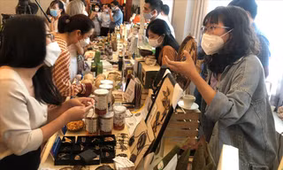 Băng Nhi (bên phải, ở Bến Tre) giới thiệu trang sức từ gáo dừa cho khách 