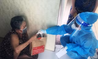 Nhân viên y tế phát túi thuốc cho F0 thực hiện cách ly, điều trị tại nhà