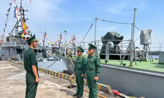 Thiếu úy Trần Văn Tân (bên trái) - Phó Thuyền trưởng Tàu BP 28.01.62 thuộc Hải đội 1, Hải đoàn Biên phòng 28 phổ biến nhiệm vụ canh trực Tết cho chiến sĩ của tàu 