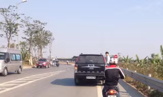 Nam thanh niên đu bám bên hông chiếc xe hạng sang. Ảnh cắt từ clip.
