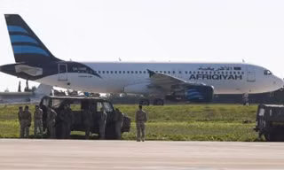 Binh sĩ Malta kiểm tra chiếc Airbus A320 trên đường băng sân bay quốc tế Malta. Ảnh: Reuters.