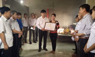 Đoàn công tác Bộ Giáo dục và Đào tạo truy tặng bằng khen cho em Trần Thị Thu Hà. Ảnh: Hoàng Lam.