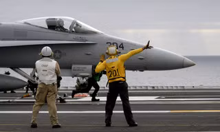 Các kỹ thuật viên chuẩn bị phóng một tiêm kích F-18. Ảnh: Wikipedia.