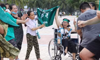 Dù ngồi xe lăn, chị Đặng Thị Bé vẫn lắc lư theo những giai điệu sôi động Ảnh: Giang Thanh