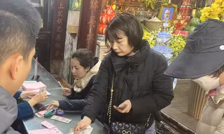 Người dân đóng tiền để đăng ký làm lễ cầu an, dâng sao giải hạn tại chùa Phúc Khánh (Thịnh Quang, Đống Đa, Hà Nội) Ảnh: VIỆT KHÔI
