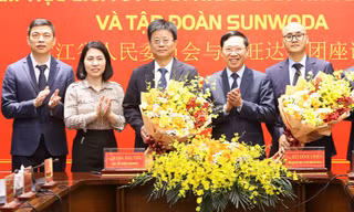 Chủ tịch UBND tỉnh Bắc Giang Lê Ánh Dương (ở giữa) tặng hoa chúc mừng Tập đoàn Sunwoda (bên trái) và chủ đầu tư hạ tầng KCN Yên Lư ký kết hợp đồng nguyên tắc đầu.