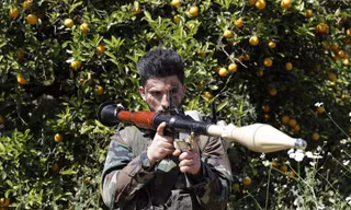 Thành viên Lực lượng Dân chủ Syria (SDF) bên đống vũ khí thu được của IS. Ảnh: Getty Images.