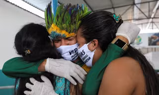 Anh Miqueias Moreira Kokama, con trai tù trưởng Messias Kokama, ôm người thân trong đám tang bố ở thành phố Manaus của Brazil hôm 14/5. Tù trưởng qua đời ở tuổi 53. Ảnh: Reuters.