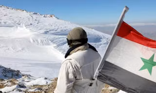 Một binh sĩ Syria mang quốc kỳ Syria. Ảnh: SANA/RT. 