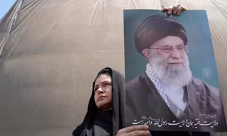 Một người dân giương cao ảnh chân dung Đại giáo chủ Iran trong cuộc biểu tình tại Tehran ngày 13/6. (Ảnh: AP)